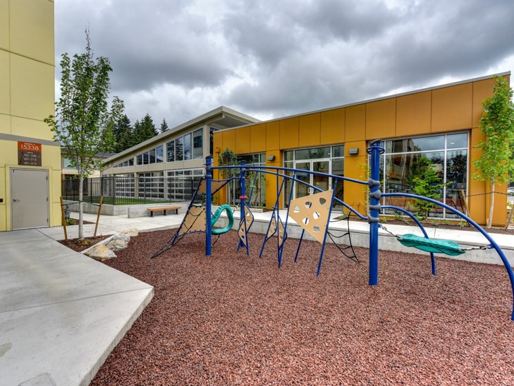 Outdoor Playground with Jungle Gym, Wood Chip Floor, Rocks and Building Exterior